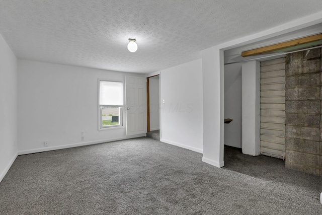 unfurnished bedroom featuring carpet flooring, a textured ceiling, and baseboards