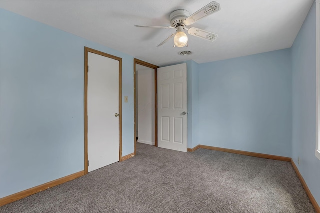 unfurnished bedroom with baseboards, visible vents, ceiling fan, and carpet
