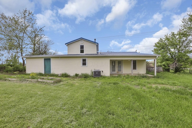rear view of property featuring cooling unit, french doors, and a lawn