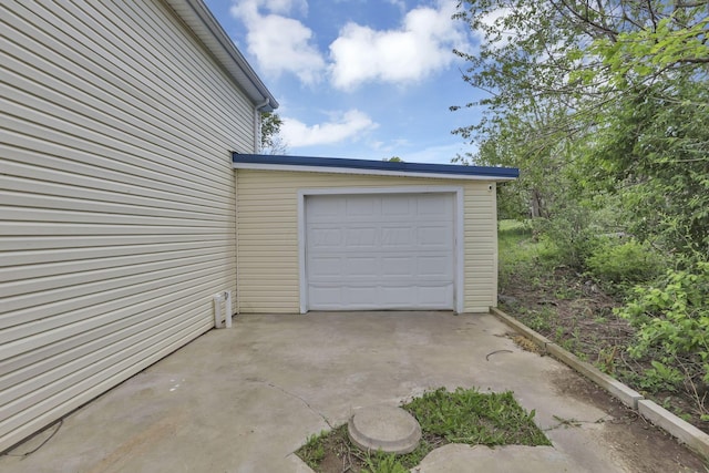garage featuring concrete driveway
