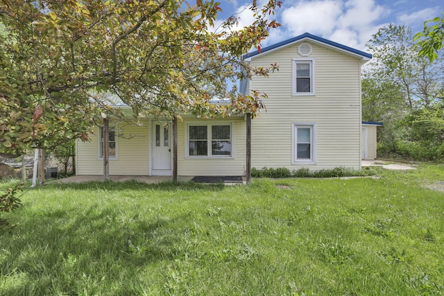 back of property with a lawn