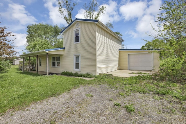 rear view of house with a lawn, driveway, and a garage