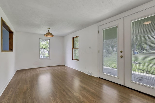 interior space featuring wood finished floors, visible vents, french doors, and a textured ceiling