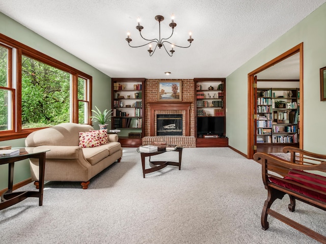 living room featuring carpet flooring, a chandelier, a textured ceiling, baseboards, and a fireplace