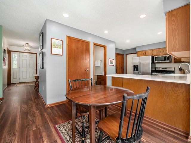 dining room with dark wood finished floors, baseboards, and recessed lighting
