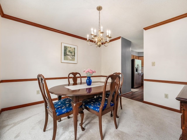 dining area with a chandelier, ornamental molding, carpet, and baseboards