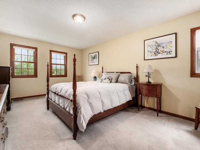 bedroom featuring light colored carpet and baseboards