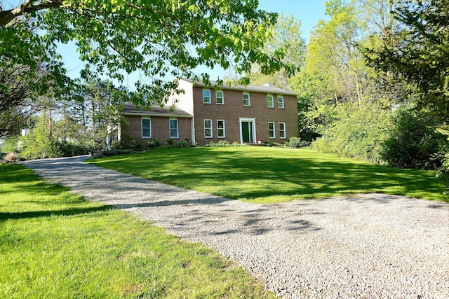 colonial home with a front yard and brick siding