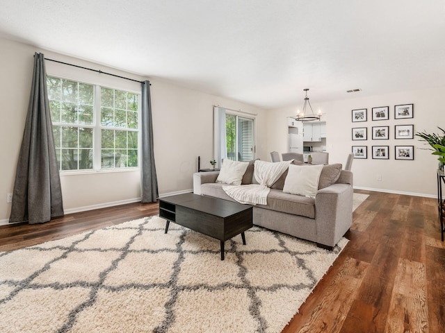 2059 Park Run Dr Unit D, Columbus, OH 43220 - living room featuring baseboards, a notable chandelier, visible vents, and wood finished floors
