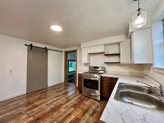 kitchen with gas range, open shelves, a sink, dark wood-style floors, and white cabinetry