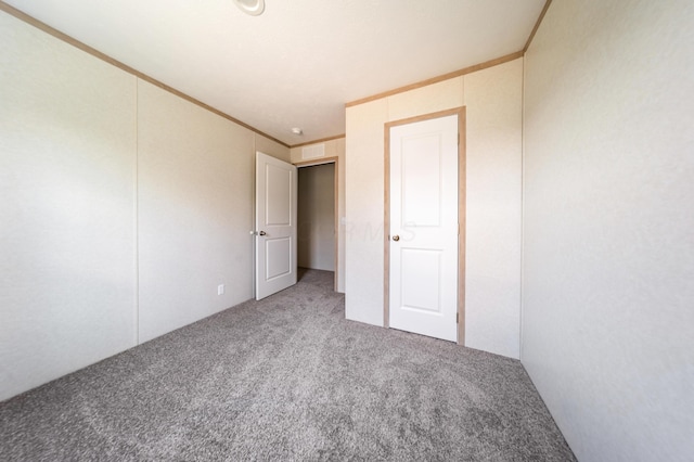 unfurnished bedroom with crown molding, carpet flooring, and visible vents