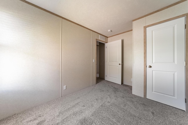 unfurnished bedroom with ornamental molding, carpet flooring, and visible vents