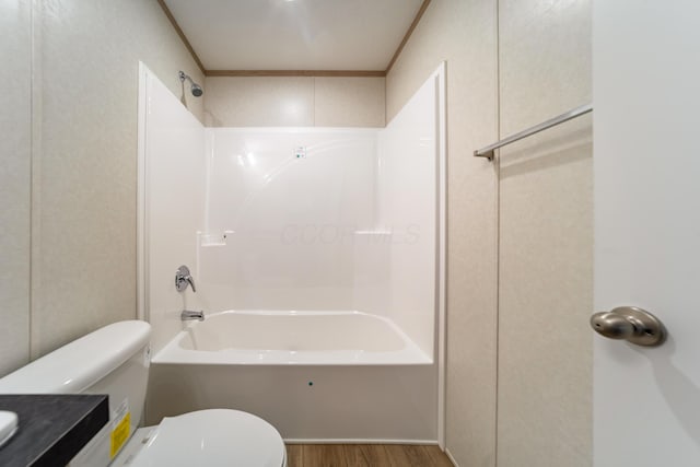 bathroom with toilet,  shower combination, wood finished floors, and vanity