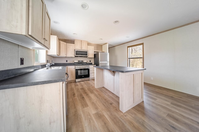 kitchen featuring dark countertops, appliances with stainless steel finishes, and a healthy amount of sunlight
