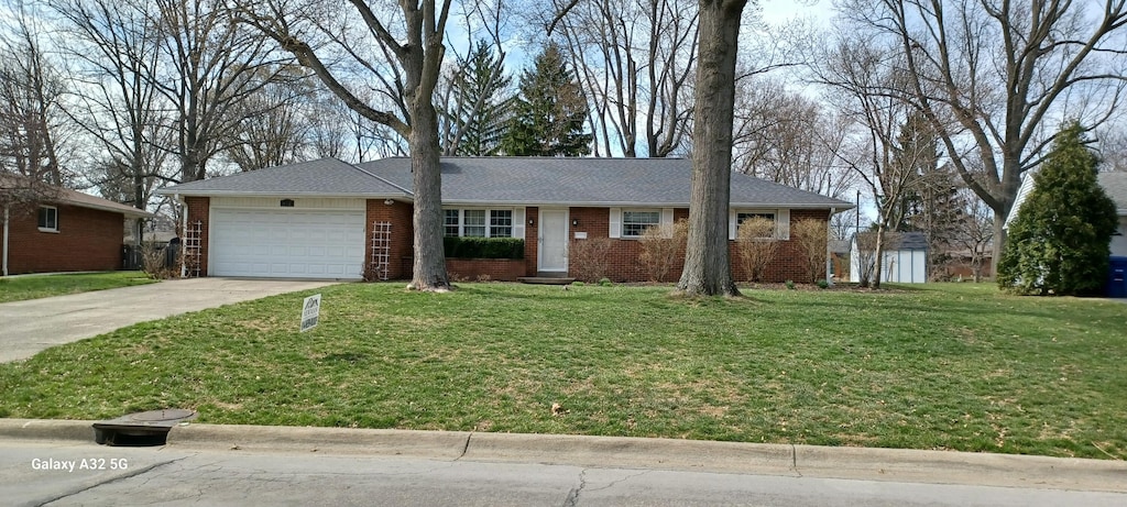 ranch-style home featuring an attached garage, driveway, brick siding, and a front yard