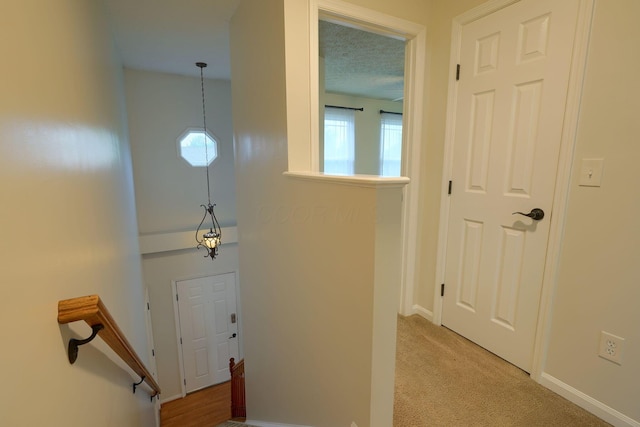 hallway featuring light carpet and baseboards