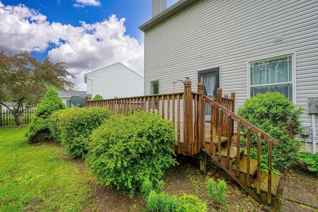 view of home's exterior featuring a chimney, a wooden deck, and a yard