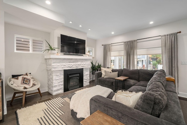 living room with recessed lighting, baseboards, and a fireplace