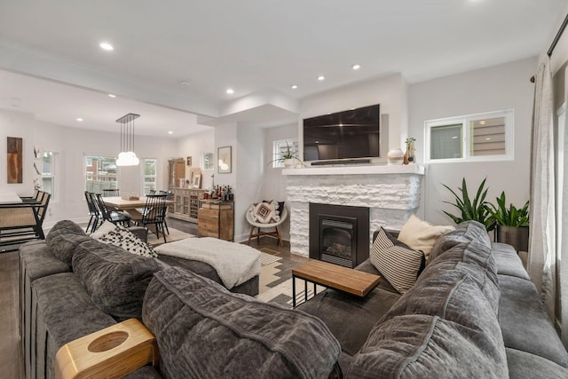 living area featuring recessed lighting, baseboards, wood finished floors, and a fireplace