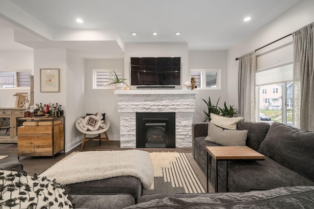living room featuring a fireplace, recessed lighting, wood finished floors, and a wealth of natural light