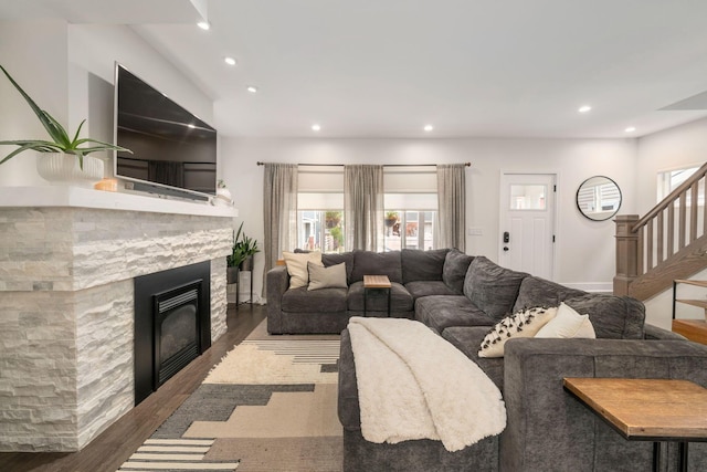 living area featuring stairway, a fireplace, recessed lighting, and wood finished floors