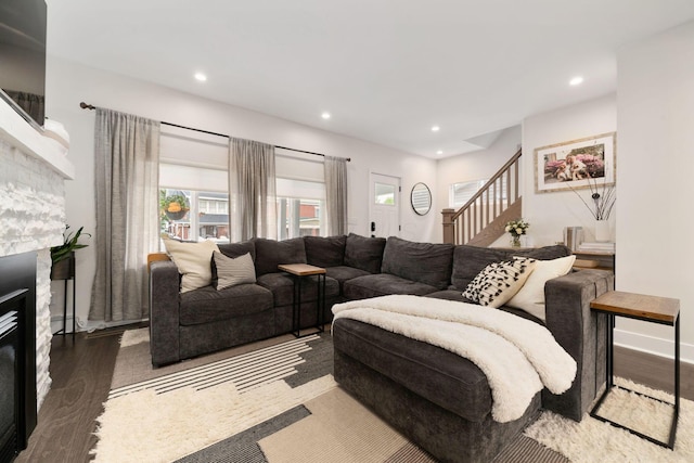 living room with a fireplace, stairs, wood finished floors, baseboards, and recessed lighting