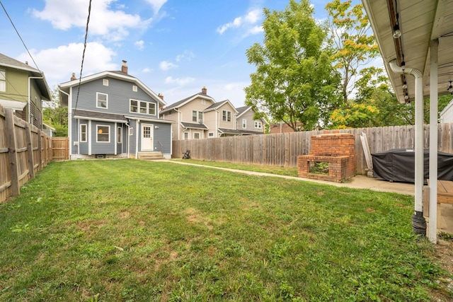 view of yard with a fenced backyard, a residential view, and entry steps