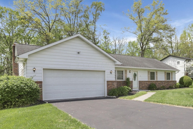 ranch-style home featuring a front lawn, brick siding, a garage, and aphalt driveway