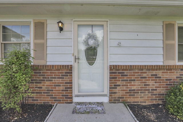 property entrance featuring brick siding