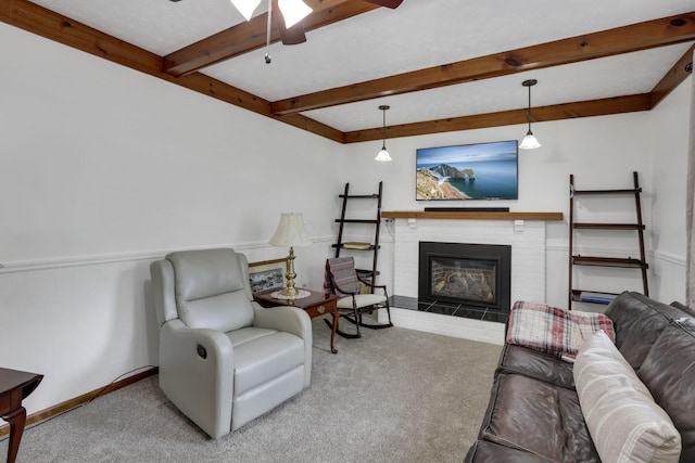 carpeted living room featuring a brick fireplace, a ceiling fan, beamed ceiling, and baseboards