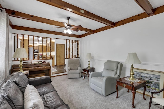 living room featuring a ceiling fan, beamed ceiling, and carpet