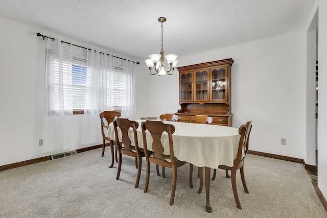 dining room with baseboards, visible vents, light carpet, and a notable chandelier