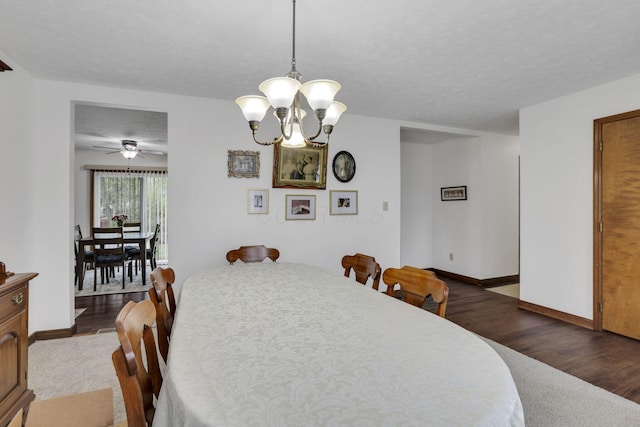 dining area featuring dark wood-type flooring, a textured ceiling, and baseboards
