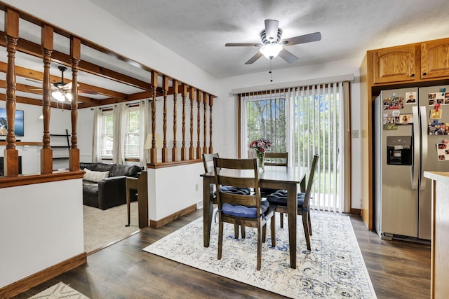dining space with baseboards, a textured ceiling, dark wood-style flooring, and ceiling fan