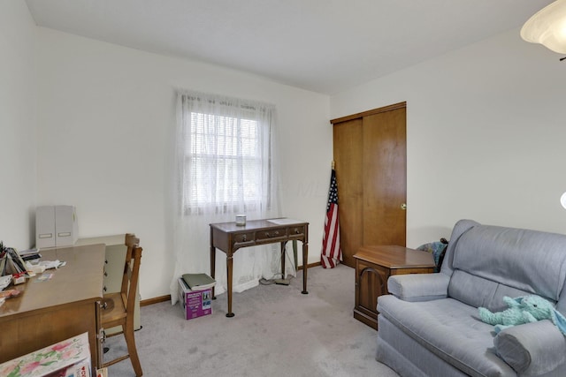 home office featuring baseboards and light carpet