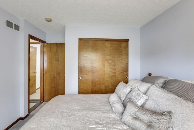 carpeted bedroom with visible vents and a closet