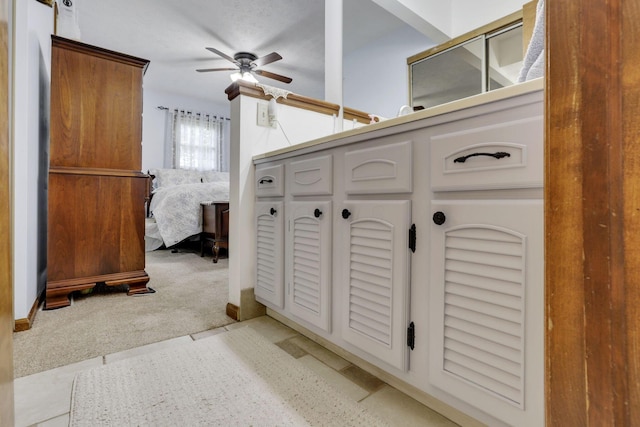 interior space featuring a ceiling fan and ensuite bath