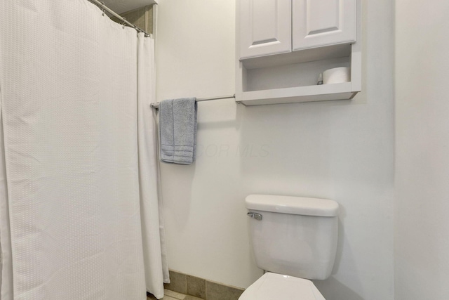 full bath with toilet and baseboards