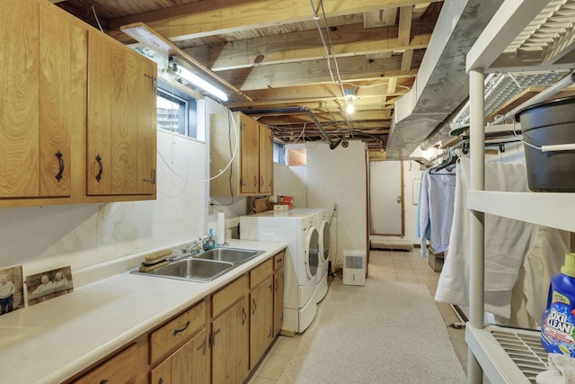 clothes washing area with washer and dryer, cabinet space, light tile patterned floors, and a sink