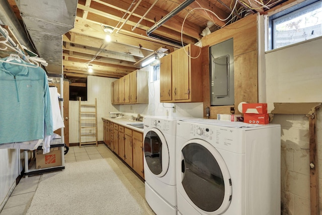 laundry area featuring electric panel, washer and clothes dryer, cabinet space, and light tile patterned floors