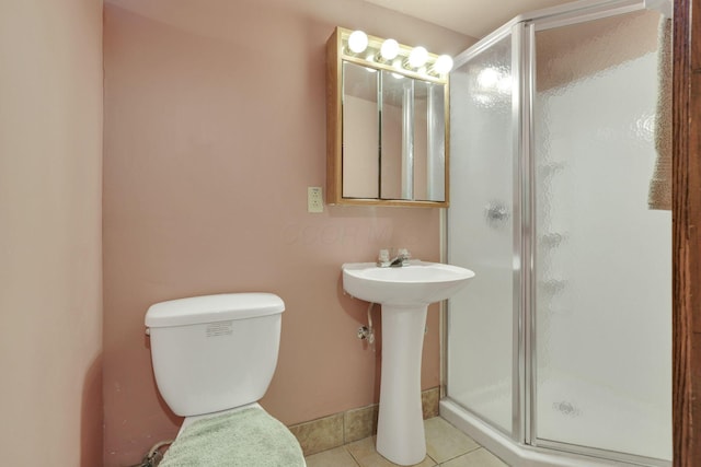 bathroom with a stall shower, tile patterned floors, and toilet