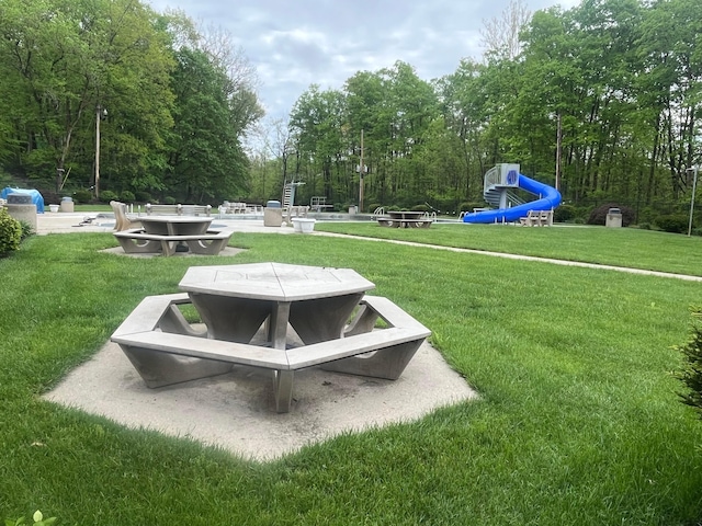view of home's community featuring a lawn and a fire pit