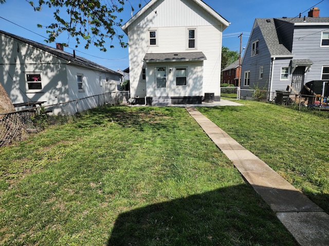 back of house with a yard, board and batten siding, central air condition unit, entry steps, and a fenced backyard