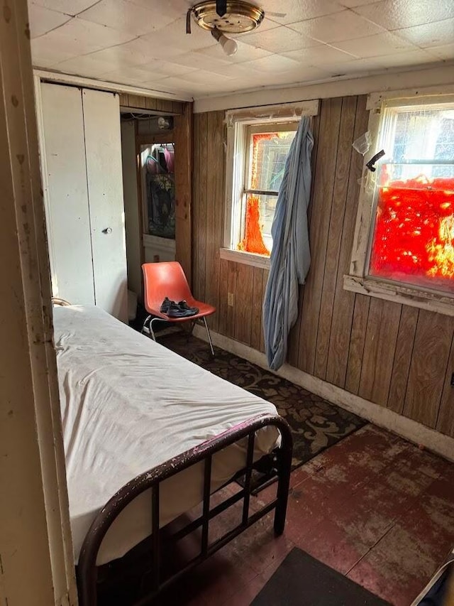 bedroom featuring wooden walls and baseboards