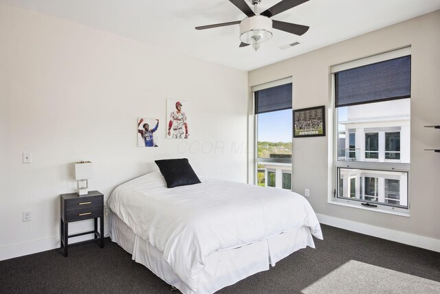 bedroom featuring dark colored carpet, baseboards, and a ceiling fan
