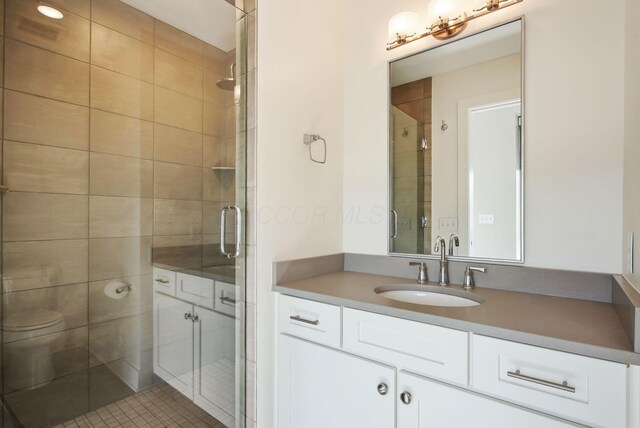 full bath with a shower stall, vanity, and toilet