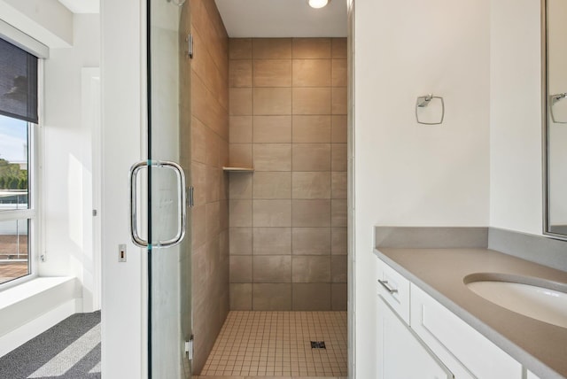 bathroom with a stall shower, vanity, recessed lighting, and baseboards