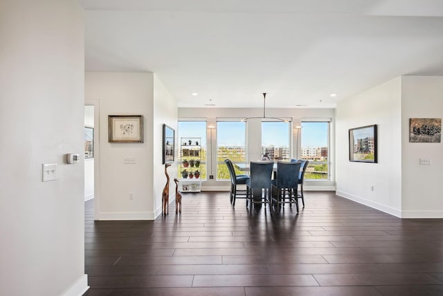 dining space with baseboards, dark wood finished floors, and recessed lighting