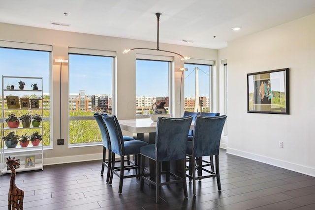 dining space with baseboards, dark wood-type flooring, and recessed lighting