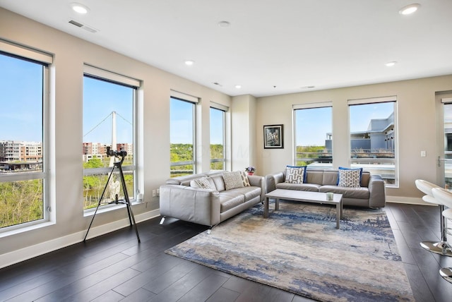 living area with plenty of natural light, baseboards, dark wood-style flooring, and recessed lighting